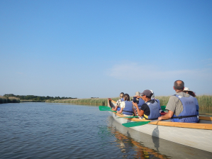 Un cano&euml; collectif avec un groupe de personnes en gilets de sauvetages naviguent sur la Leyre