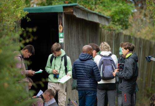 Un groupe de lyc&eacute;ens se tient devant l'observatoire 6 de la R&eacute;serve ornithologique du Teich, ils &eacute;crivent sur des portes-documents.