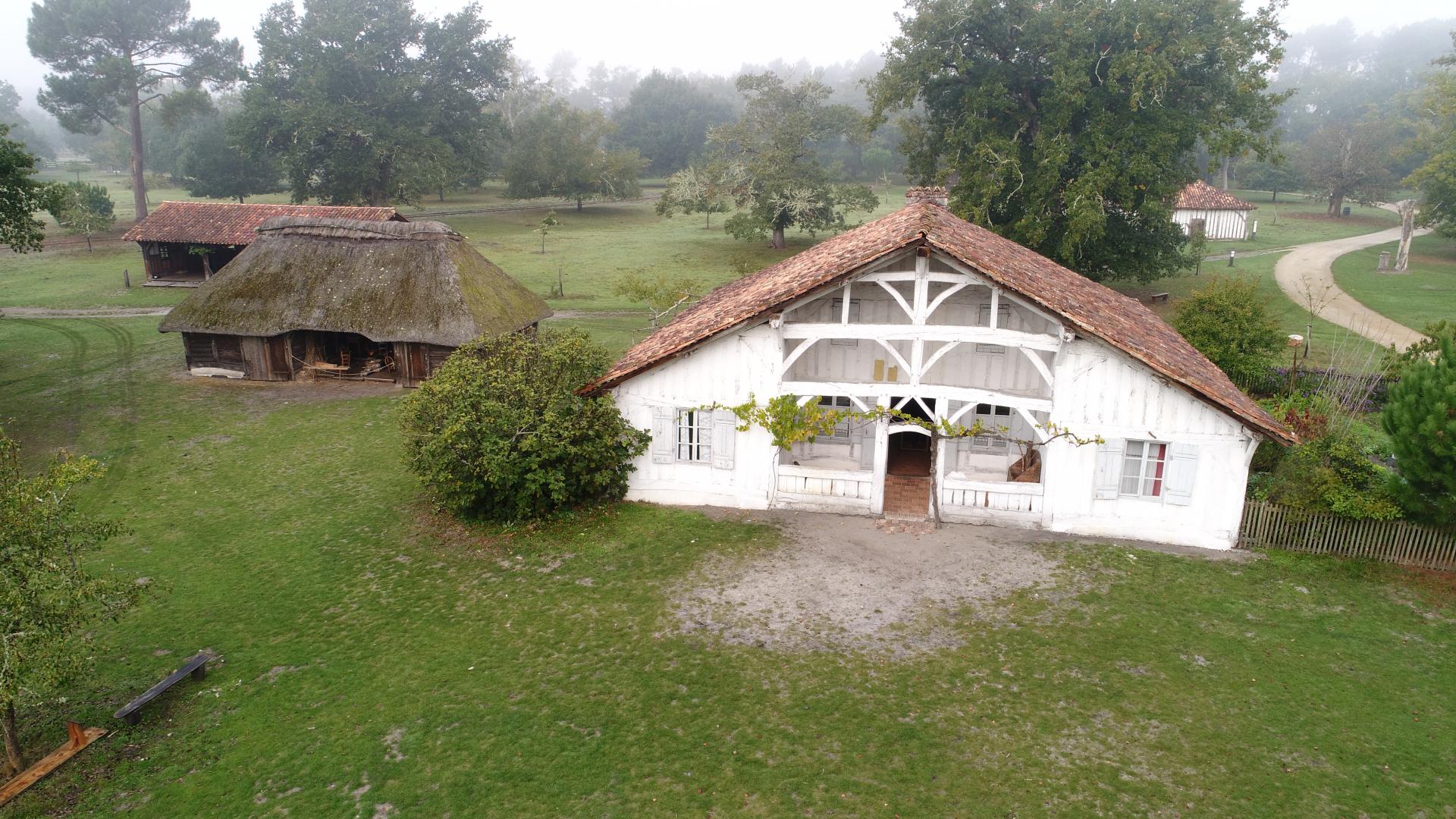Airial avec maison et dépendances, vu du ciel, dans la brume